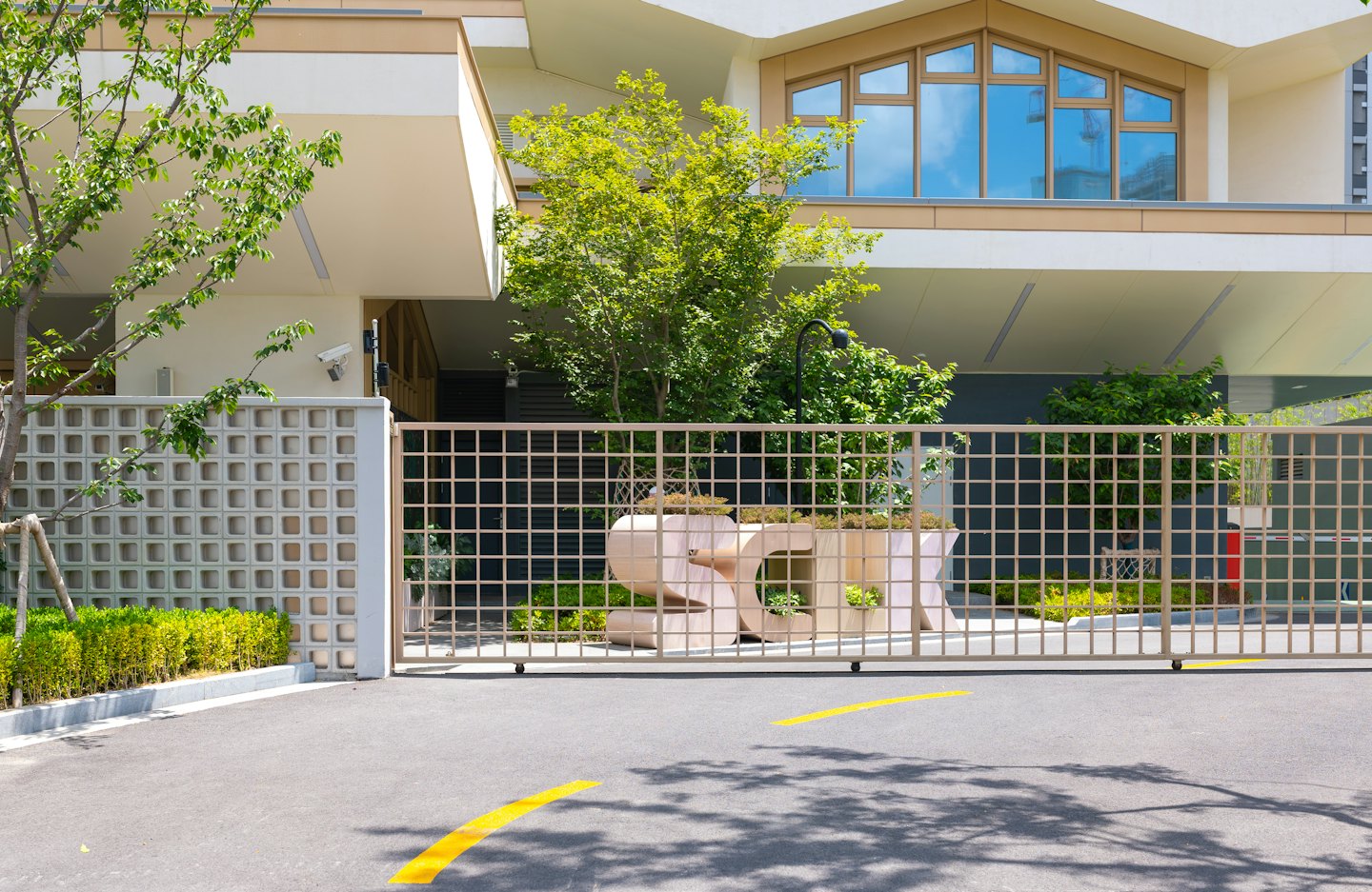 Modern building entrance with planter box security gate and trees.
